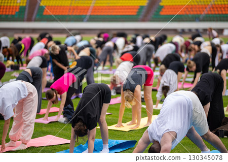 Group yoga session on stadium lawn in FYSM style Group yoga session on stadium lawn in FYSM style 130345078