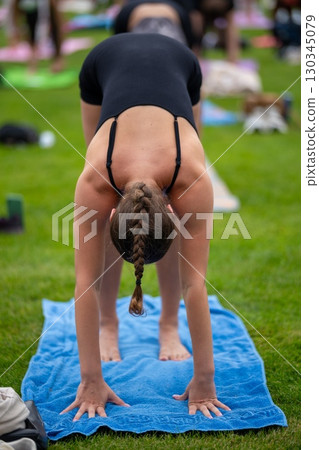 A girl in Uttanasana pose during a group FYSM yoga class 130345079