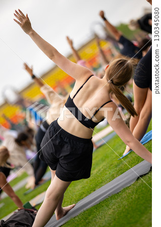 Group yoga session on stadium lawn in FYSM style 130345080