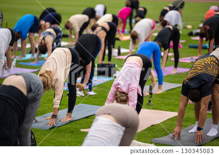 Group yoga session on stadium lawn in FYSM style Group yoga session on stadium lawn in FYSM style 130345083