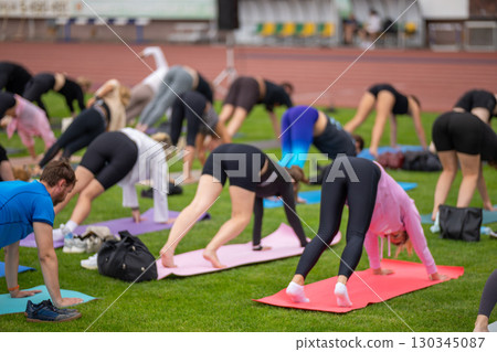 Group yoga session on stadium lawn in FYSM style Group yoga session on stadium lawn in FYSM style 130345087