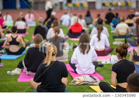 Group yoga session on stadium lawn in FYSM style Group yoga session on stadium lawn in FYSM style 130345090