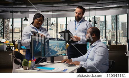 Team of engineers in office doing green energy production technology testing. Teamworking colleagues research cutting edge solutions for biodiversity conservation in renewable energy sector, camera A 130345181