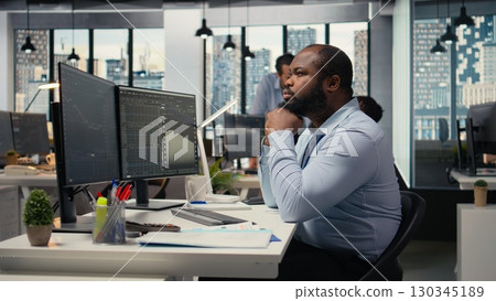 Day trader analyzes stock market price charts, doing thinking, making buy and sell decisions in prop firm office. Man doing brainstorming, placing client orders using trading platform Day trader analyzes stock market price charts, doing thinking, making buy and sell decisions in prop firm office. Man doing brainstorming, placing client orders using trading platform 130345189