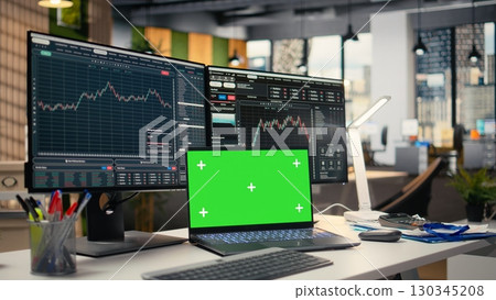Stock market metrics diagrams displayed on green screen laptop in prop firm office. Workstation in forex company workspace with live financial data visible on mockup notebook 130345208