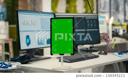 Contemporary office space equipped with green screen on tablet, empty workstation used for professional management and business growth objectives. Multinational company tasks. Contemporary office space equipped with green screen on tablet, empty workstation used for professional management and business growth objectives. Multinational company tasks. 130345211