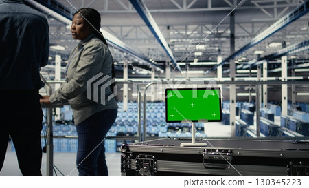 Data center IT professionals check AI dashboard using isolated screen tablet. Server room developers test artificial intelligence tools on chroma key device to ensure reliable performance, camera A Data center IT professionals check AI dashboard using isolated screen tablet. Server room developers test artificial intelligence tools on chroma key device to ensure reliable performance, camera A 130345223