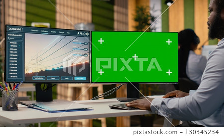 Engineer works on power line tower CAD design on isolated screen PC in office. RD department expert uses software on mockup computer to optimize transmission tower systems, camera B 130345234