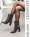 Girl in black tights and black boots 130345359