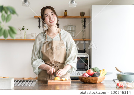 Young Asian woman cooking in the kitchen (cutting, knife, cooking, home cooking) Young Asian woman cooking in the kitchen (cutting, knife, cooking, home cooking) 130346314