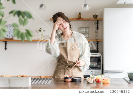 Woman packing lunch in the kitchen (fatigue, tiredness, hardship, burden, overwork, hardship) Woman packing lunch in the kitchen (fatigue, tiredness, hardship, burden, overwork, hardship) 130346322