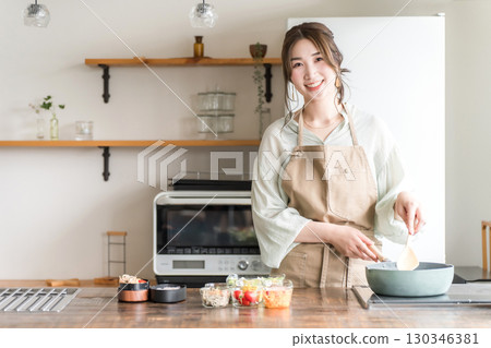 Young Asian woman (mother, wife, housewife) preparing lunch in the kitchen Young Asian woman (mother, wife, housewife) preparing lunch in the kitchen 130346381