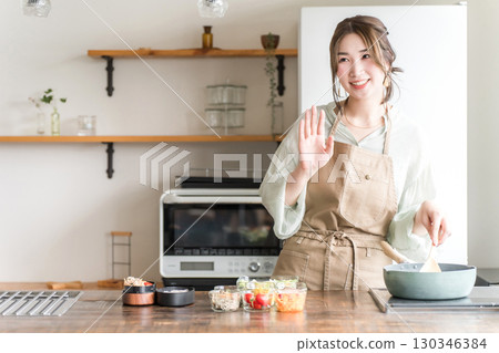 Young Asian woman making lunch in the kitchen (Good morning, greeting) Young Asian woman making lunch in the kitchen (Good morning, greeting) 130346384