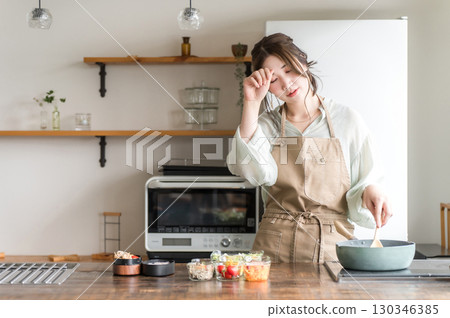一位婦女在廚房做午餐（疲倦、疲倦、艱辛、負擔、勞累過度、艱辛） 130346385