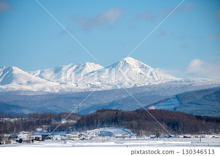陽光明媚的冬日，白雪覆蓋的山脈和稻田 130346513