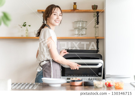 一位女士在廚房使用微波爐(微笑) 一位女士在廚房使用微波爐(微笑) 130346715