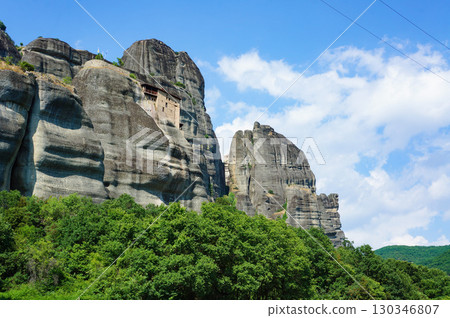 Strangely shaped rocks formed over time towering over the blue sky 130346807