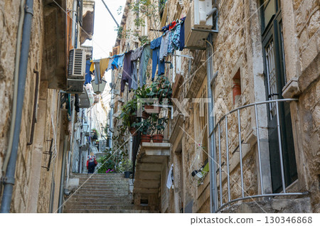 A dimly lit alleyway overseas with laundry hanging out to dry 130346868