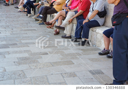The feet of people sitting on stone stools 130346888
