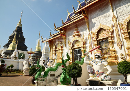 Statues of sitting white Giant holding a baton in Thai art, decorate the front of the Church or Chapel at Wat Den Sali Si Mueang Kaen temple. Located at Chaing Mai Province in Thailand. 130347091