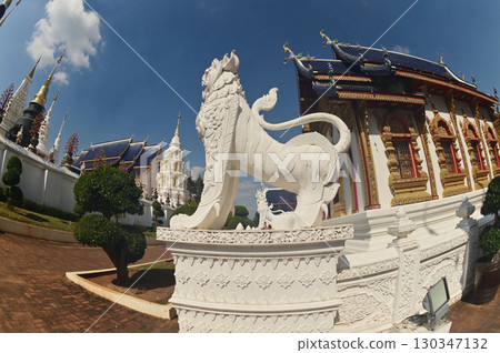 Statues of white Singha, which are animals in Thai art, decorate the front of the Church or Chapel and pagoda at Wat Den Sali Si Mueang Kaen temple. Located at Chaing Mai Province in Thailand. 130347132