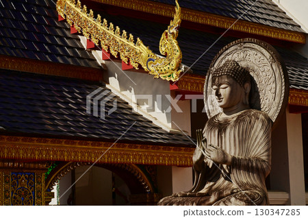 Outdoor stone sitting Buddha statue in Thai art decorate front of the Church at Wat Den Sali Si Mueang Kaen temple. Located at Chiang Mai Province in Thailand. Outdoor stone sitting Buddha statue in Thai art decorate front of the Church at Wat Den Sali Si Mueang Kaen temple. Located at Chiang Mai Province in Thailand. 130347285