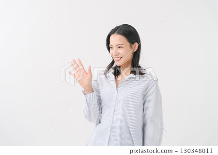 Smiling middle-aged woman in a shirt waving Smiling middle-aged woman in a shirt waving 130348011