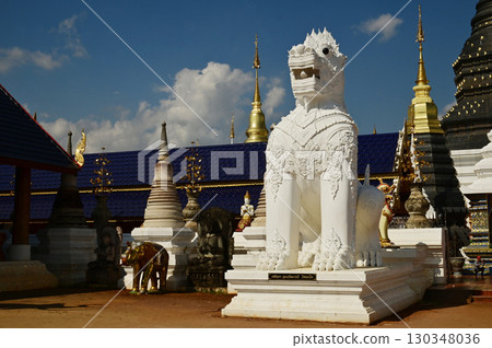 Statues of white Singha, which are animals in Thai art, decorate the front of the pagoda at Wat Den Sali Si Mueang Kaen temple. Located at Chaing Mai Province in Thailand. 130348036