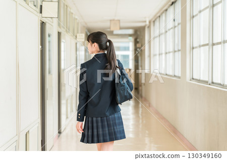 Back view of female elementary, junior high and high school students in uniform walking down a school corridor Back view of female elementary, junior high and high school students in uniform walking down a school corridor 130349160