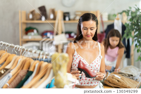 Middle-aged woman choosing heels in clothing store Middle-aged woman choosing heels in clothing store 130349299