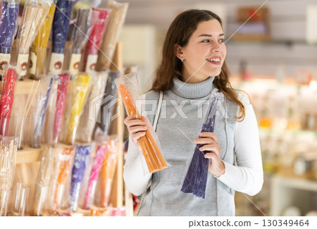 Young woman choosing incense sticks in store Young woman choosing incense sticks in store 130349464