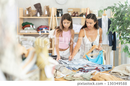 Family customer choose denim jeans or shorts in store Family customer choose denim jeans or shorts in store 130349588