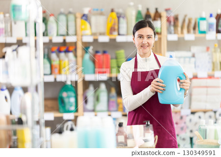 Female saleswoman offering detergent in supermarket Female saleswoman offering detergent in supermarket 130349591