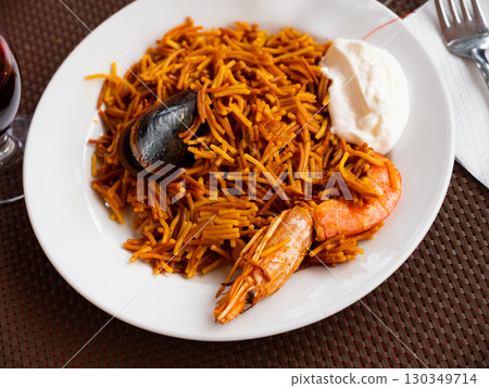 Seafood fideua with shrimps, mussels served on plate with aioli Seafood fideua with shrimps, mussels served on plate with aioli 130349714