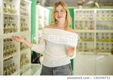 Girl seller invite and greeting clients in cosmetic shop 130349752