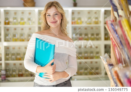 Girl seller with paper document make inventory in perfume store Girl seller with paper document make inventory in perfume store 130349775