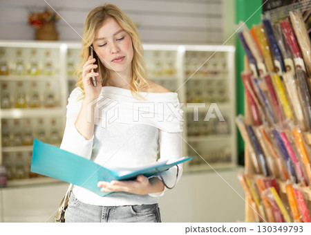 Girl reads accounting documents and talks on phone Girl reads accounting documents and talks on phone 130349793