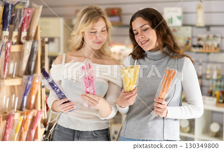 Two young women choosing incense sticks Two young women choosing incense sticks 130349800