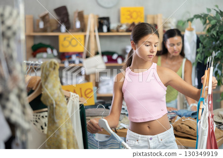 Teenage girl choosing something for summer in clothing store 130349919