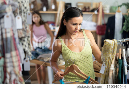 Middle-aged woman choosing something for summer in clothing store 130349944