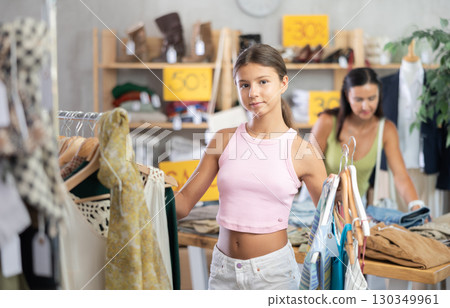 Happy teenage girl choosing something for summer in clothing store 130349961
