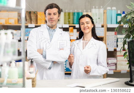 Portrait of two positive pharmacists in modern drugstore Portrait of two positive pharmacists in modern drugstore 130350022