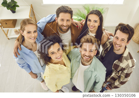 Top view portrait of a group of friends standing together at home and looking cheerful at camera. 130350106