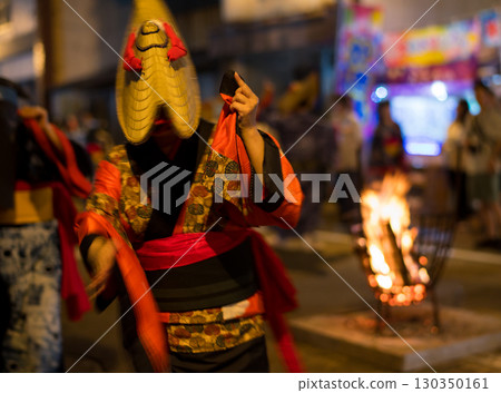 2025 年，秋田縣西馬內盂蘭盆舞節上，一位頭戴草帽、穿著捲邊和服的女子在跳舞。 130350161