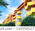 Bright residential building in a Polish city with yellow and orange balconies under a clear blue sky 130350527