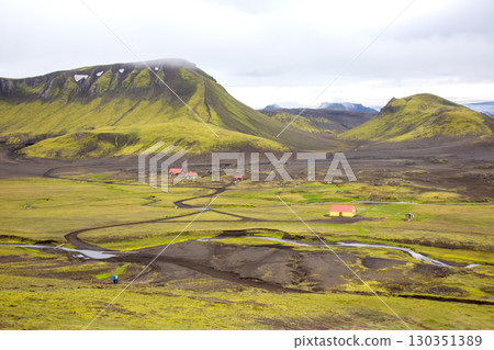 Scenic view of Icelandic landscape with mountains, green fields, and scattered buildings Scenic view of Icelandic landscape with mountains, green fields, and scattered buildings 130351389