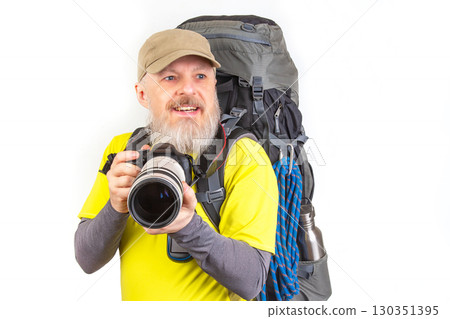 Prepared hiker smiles while holding camera and wearing a backpack for outdoor adventure 130351395