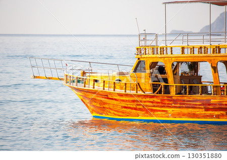 Traditional wooden boat anchored in calm waters near Turkey's coast at sunset Traditional wooden boat anchored in calm waters near Turkey's coast at sunset 130351880