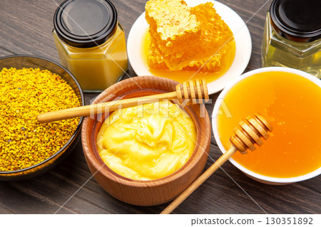 Honey products displayed with jars and honeycomb on wooden surface at a local market 130351892