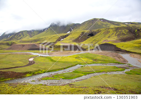 Summer in Iceland's highlands features mossy hills and a winding river 130351903